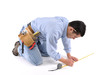Construction worker measuring the floor over white background. Construction worker measuring the floor over white background.