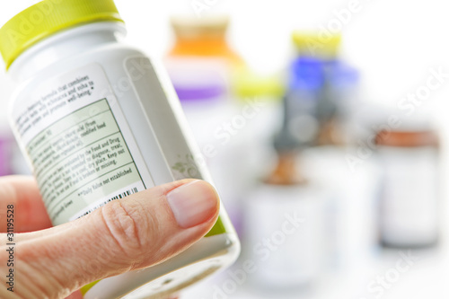 Photo: Hand holding medicine bottle Hand holding medicine bottle