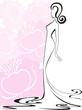woman in a long dress against a background of pink flowers
