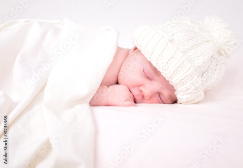 Photo: Little Newborn Baby Sleeping on White with Blanket Little Newborn Baby Sleeping on White with Blanket