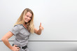 Smiling blond woman on grey background