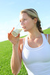 Photo: Beautiful blond woman drinking milk in countryside Beautiful blond woman drinking milk in countryside