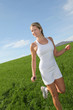Beautiful blond woman jogging in country field