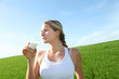 Beautiful blond woman drinking milk in countryside
