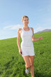 Beautiful blond woman jogging in country field