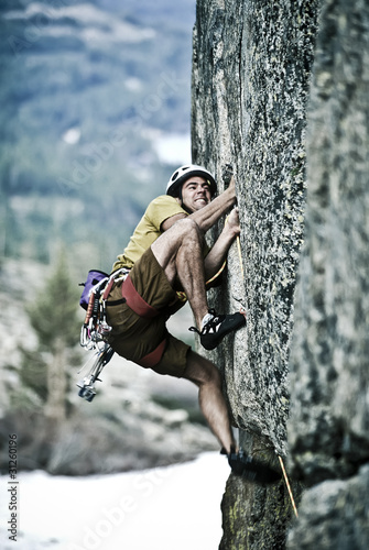 Photo: Rock climber clinging to a cliff. Rock climber clinging to a cliff.