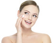 Happy woman applying cosmetic cream