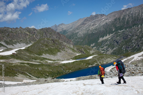 Photo: Couple of backpackers in a high mountains Couple of backpackers in a high mountains