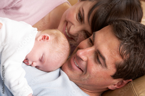 Foto: Portrait Of Proud Parents With Newborn Baby At Home Portrait Of Proud Parents With Newborn Baby At Home