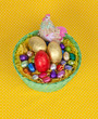 Colorful Easter chocolate eggs in a green basket