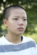 Depressed asian teen girl with shaved bald head
