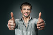 Young happy man going thumbs up