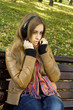 Attractive girl in park listens to music
