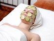 Woman with facial mask of cucumber
