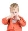 The boy drinks water from a glass