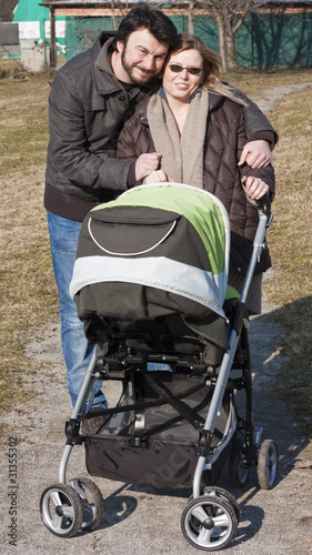 Photo: Happy Family Walking with Stroller Happy Family Walking with Stroller
