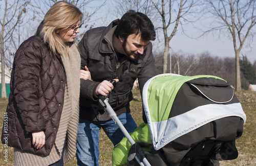 Photo: Happy Family Walking with Stroller Happy Family Walking with Stroller