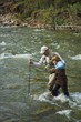 Father And Son Crossing A Mountain Fly Fishing River