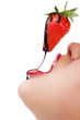 girl eating strawberry with chocolate sauc