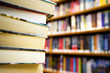 Photo: Book stack against book shelf in library Book stack against book shelf in library
