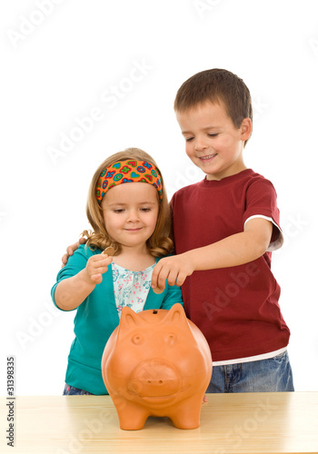 Photo: Kids saving coins in large piggy bank Kids saving coins in large piggy bank