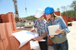 Engineers on construction site with plan