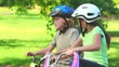Young girl cycling with her brother