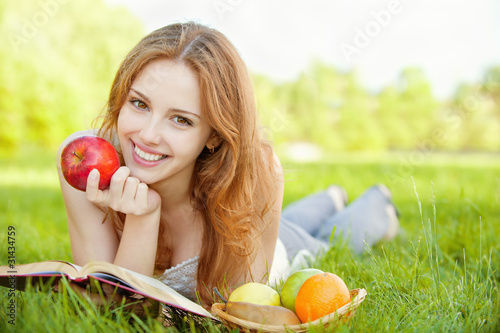 Photo: girl lying on the grass and reading a book girl lying on the grass and reading a book