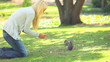 Young woman feeding a squirrel
