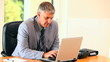 Middle-aged man in suit working on a laptop