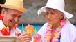 Video: Senior couple with garlands drinking colored cocktails Senior couple with garlands drinking colored cocktails