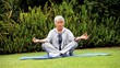 Grey-haired woman doing yoga in the garden