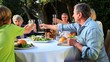 Family clinking glasses before a meal in the garden
