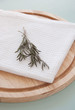 Rosemary on the white towel and breadboard
