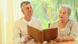 Mature couple reminiscing looking at an album 