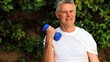 Mature man exercising with dumbells outdoors