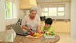 Woman showing her grandson how to cook