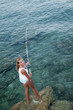 Fishing - young girl fishing at the beach