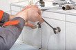 Plumber hands fixing water pipe with spanner Plumber hands fixing water pipe with spanner