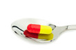 red and yellow tablet in spoon