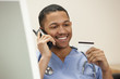 Foto: Doctor with credit card on phone Doctor with credit card on phone