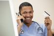 Foto: Doctor with credit card on the phone Doctor with credit card on the phone