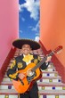 Charro Mariachi playing guitar in Mexico stairway Charro Mariachi playing guitar in Mexico stairway
