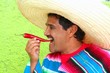 Mexican man poncho sombrero eating red hot chili Mexican man poncho sombrero eating red hot chili
