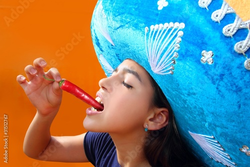 Photo: Mexican girl eating red hot chili pepper Mexican girl eating red hot chili pepper