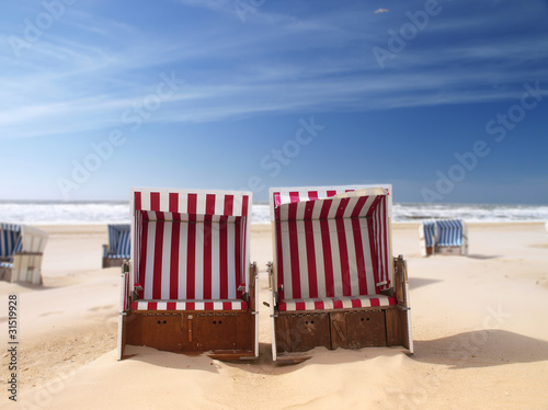 Photo: red beach chairs on a deserted sunny beach red beach chairs on a deserted sunny beach