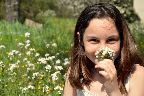 Photo: Fillette heureuse qui tient un bouquet de Pâquerettes Fillette heureuse qui tient un bouquet de Pâquerettes