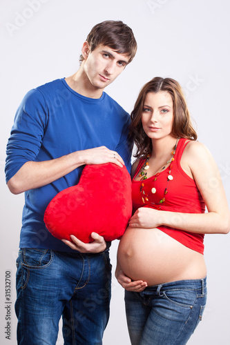 Photo: Happy man and pregnant woman with red heart Happy man and pregnant woman with red heart
