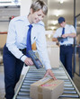 Woman scanning box on conveyor belt