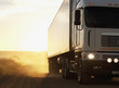 Semi-truck driving on dusty dirt road